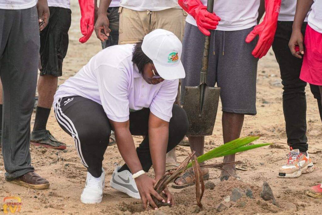 Naana Dugbakuwor Dugba II planting coconut at the beach.