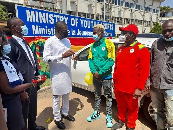 The Minister of Youth and Sports, Mr Ussif Mustapha (in white) speaking with Takyi during the car presentation