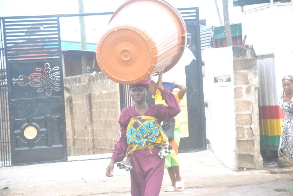 A Woman carrying a barriel.