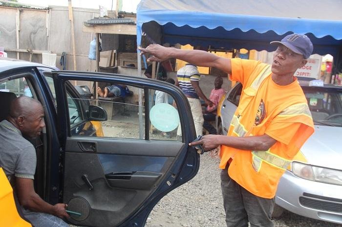 A loading boy directing passengers into a taxi