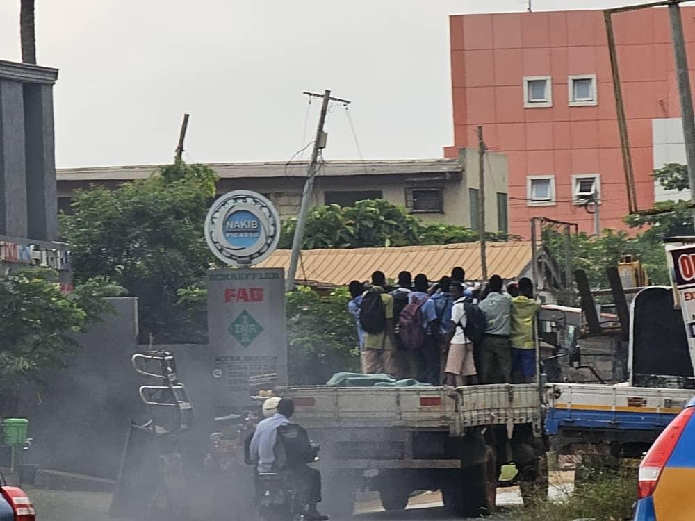 People being transported in the bucket of a vehicle