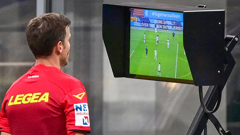 A referee conducting a video review with the aid of VAR to overturn or confirm a decision