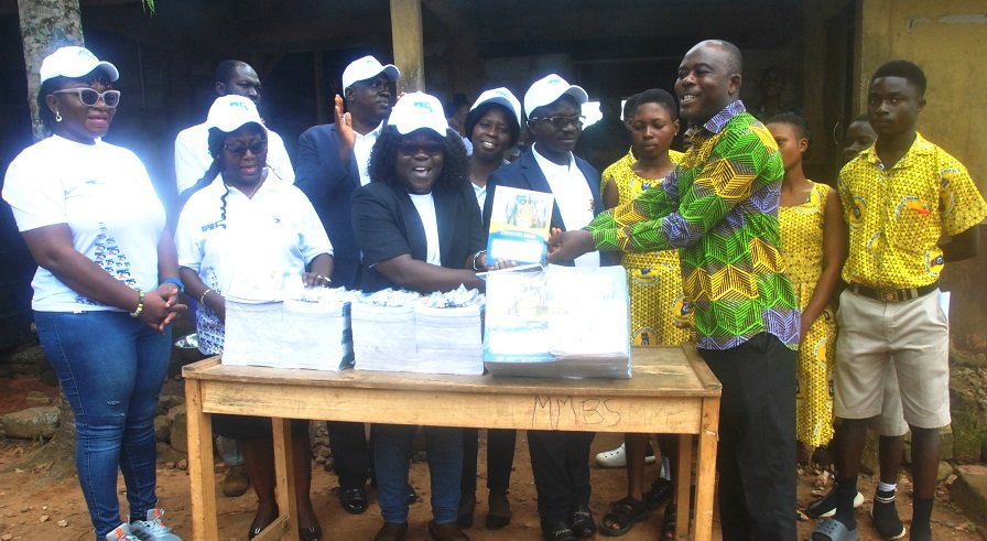 Prof. Alice Mensah presenting the books to Mr Bright Loggah the headteacher of Mpehnasem Methodis Basic school with the staff of ATU and pupils Photo: Lizzy Okai