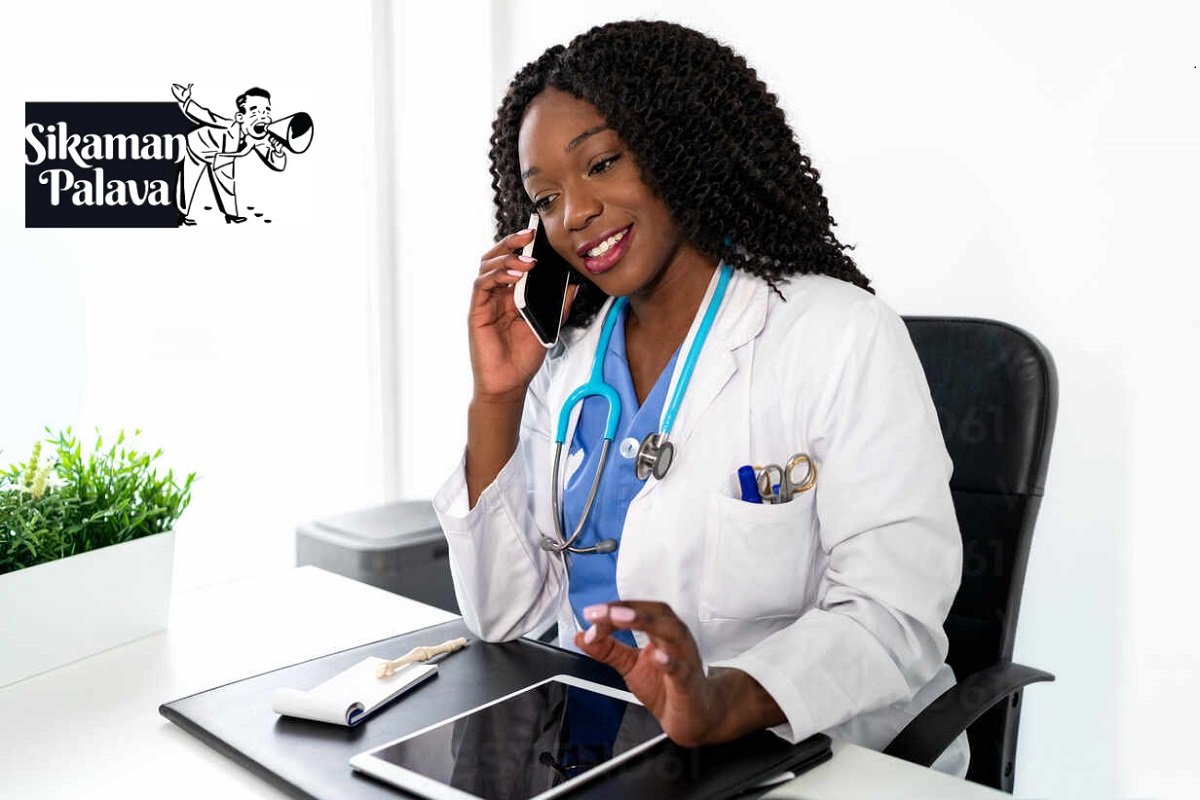 Smiling black woman speaking on smartphone in office