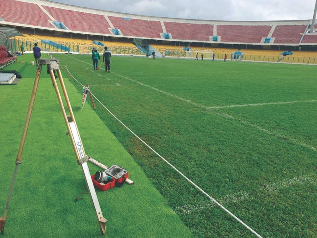 Men working on the Accra Sports Stadium pitch