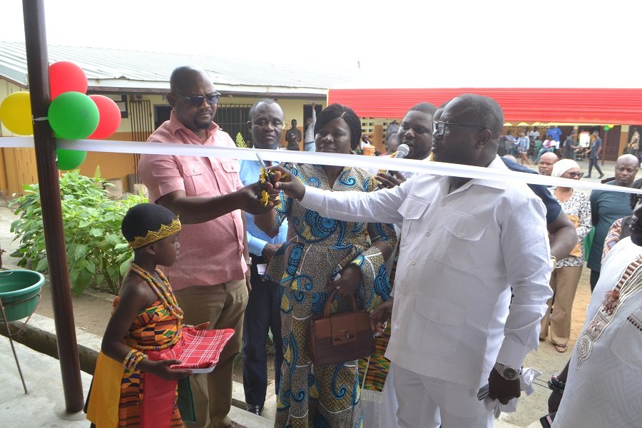 Mr Nikoi (second right) being assisted by (Mrs. Kotomah (middle) to cut the tape for the commissioning of the building programme Photo Victor A. Buxton