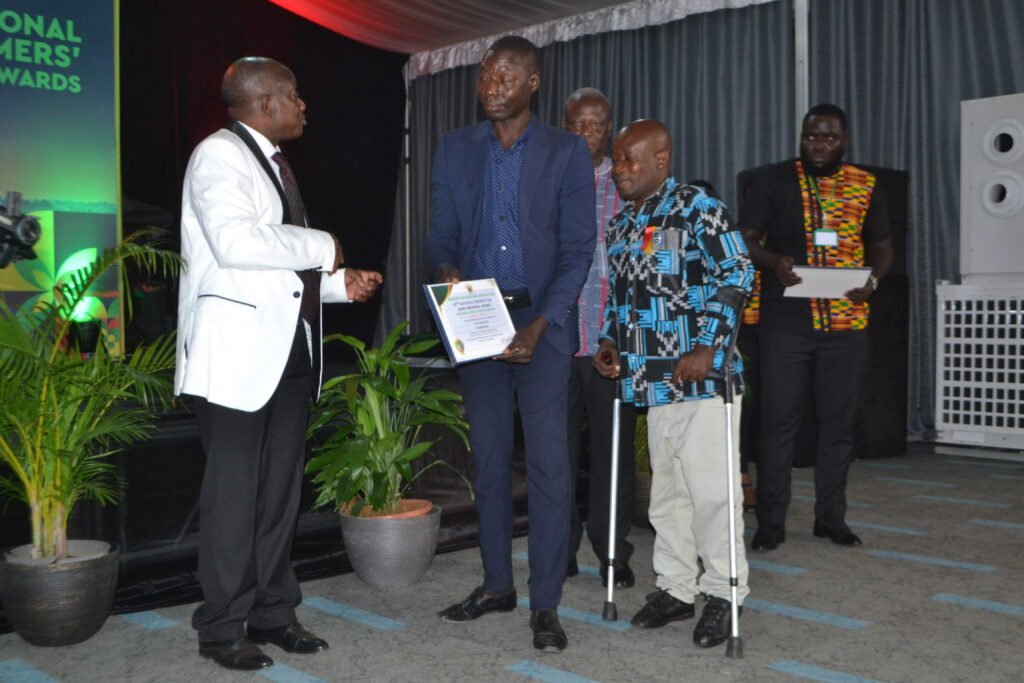 Mr. Simon Osei-Mensah (left), Ashanti Regional Minister presenting to Mr. Dominic Takyi Abeam, the Bono Regional Best Physically Chanllenged Farmer award    Photo Victor A. Buxton