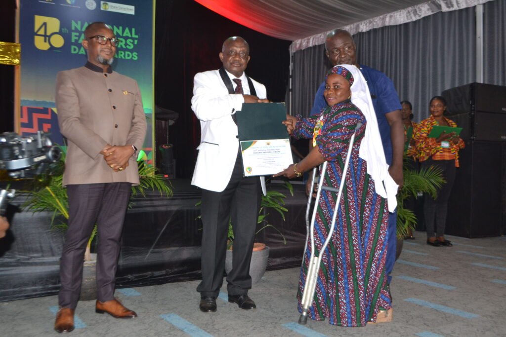 Ms. Ayisha Salifu (right) receiving from Mr. Simon Osei-Mensah(middle),Ashanti Regional Minister ,the Ashanti Regional Best Physically Challenged farmer award   Photo Victor A. Buxton