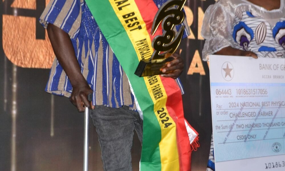 Mr. Daniel Titus-Glover (left), Greater Accra Regional Minister presenting to Mr. Stephen Addo, the National Best Physically Chanllenged Farmer Award