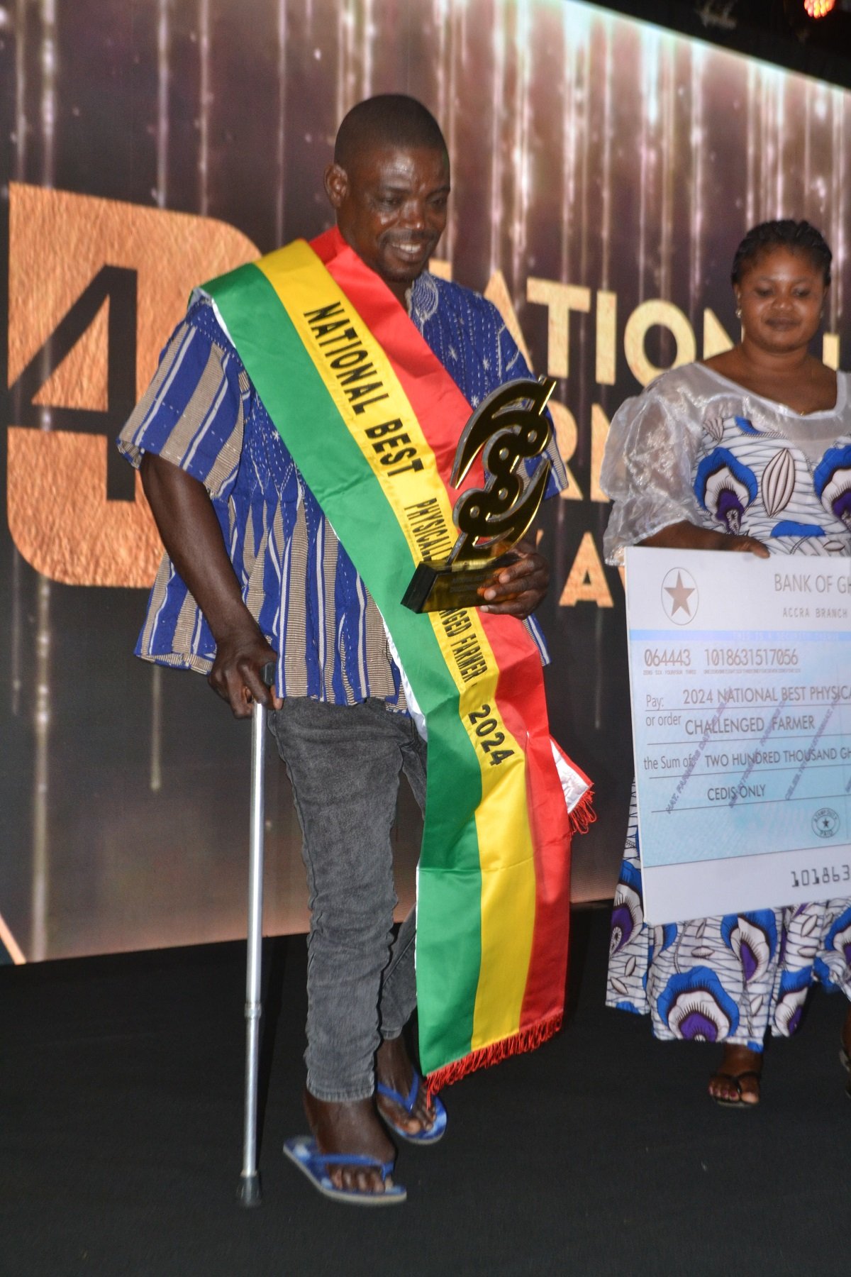 Mr. Daniel Titus-Glover (left), Greater Accra Regional Minister presenting to Mr. Stephen Addo, the National Best Physically Chanllenged Farmer Award