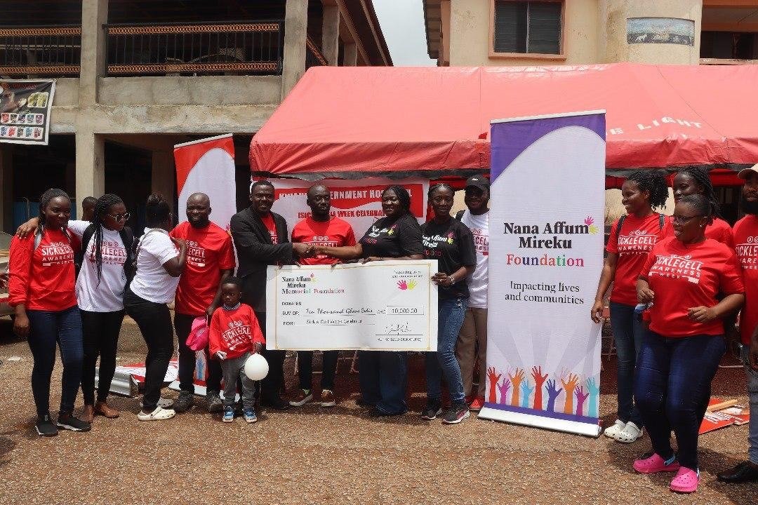 Ms Mireku presenting a dummy cheque to a representstive of the hospital