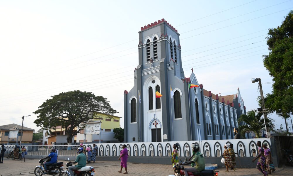 Some people walking Infront of the Catholic church in Ouidah