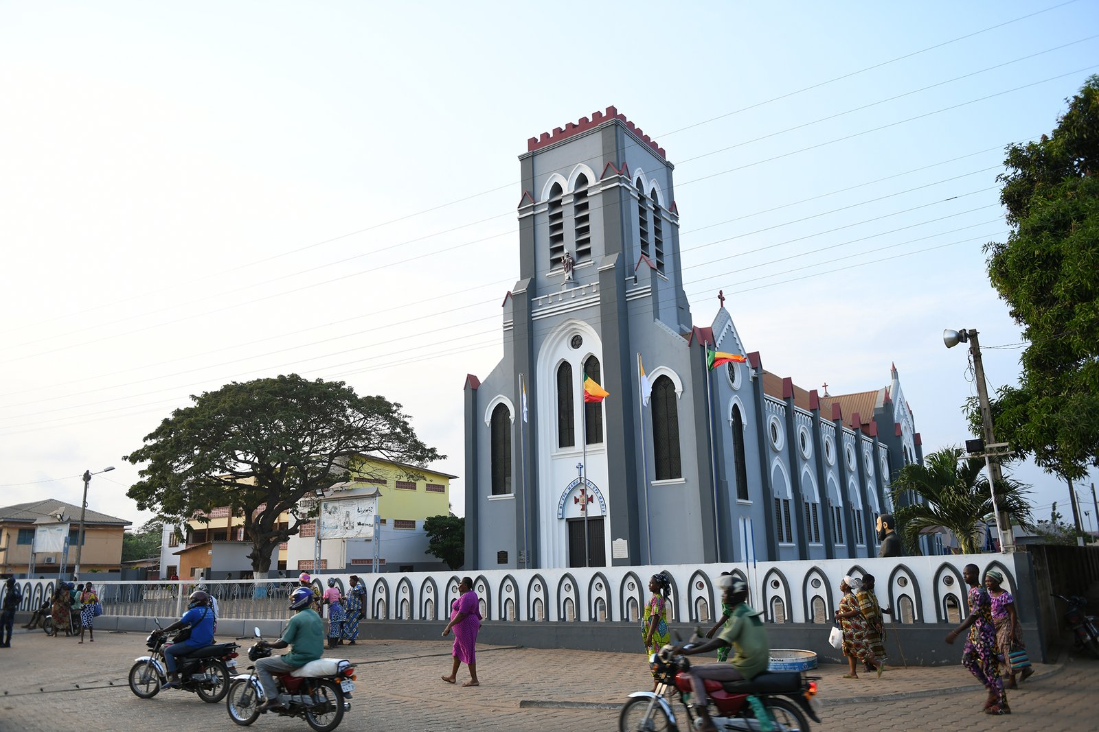 Some people walking Infront of the Catholic church in Ouidah