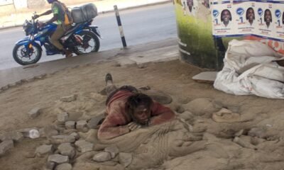 A homeless man sleeping in the sand close to the removed blocks